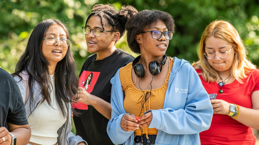 Four students smiling and engaging