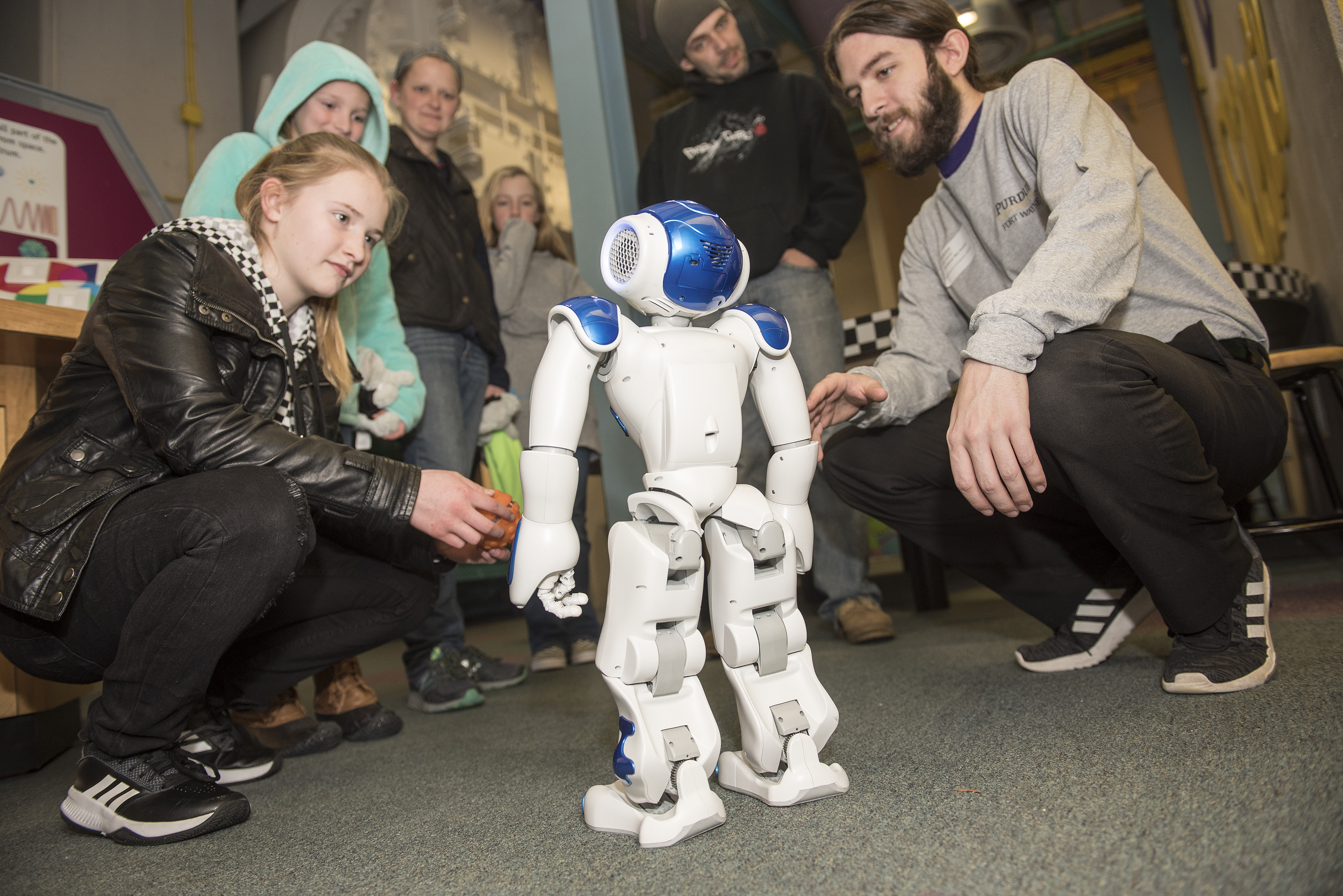 Professor showing young student a robot