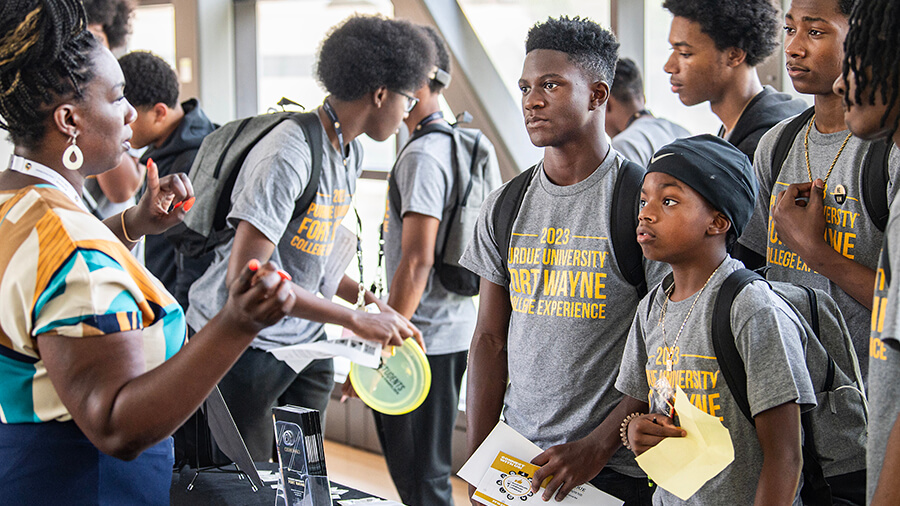 A group of students talks to a professor.