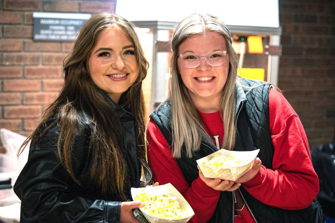 Students hold up their snacks of popcorn at a SAB event.