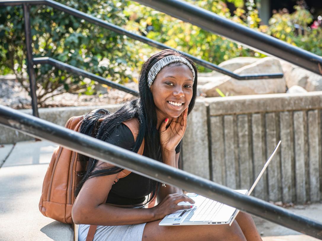 Female student sitting and studying outdoors.