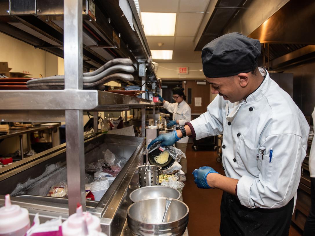 A HTM major cooks in a commercial kitchen.