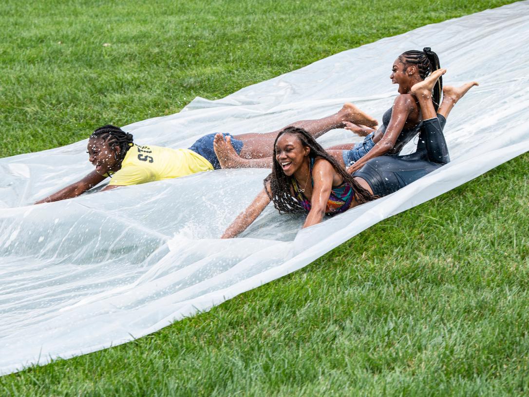 Students on a water slide on campus.