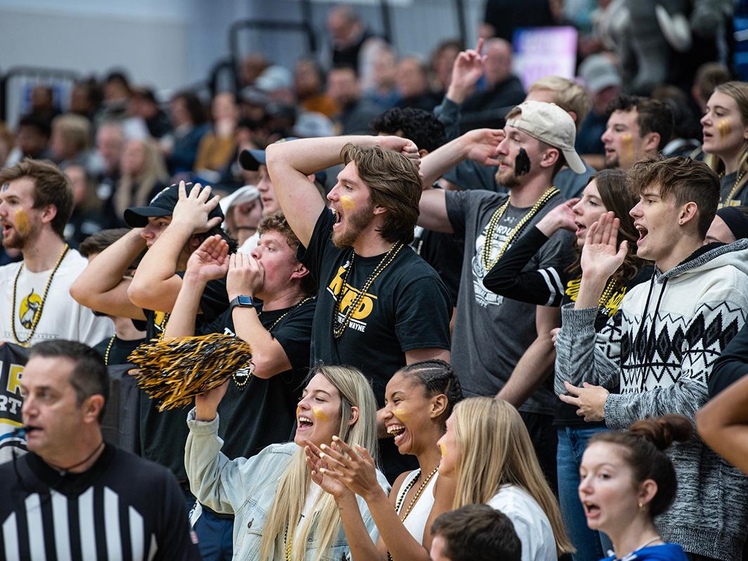 Members of The Herd cheer at a basketball game