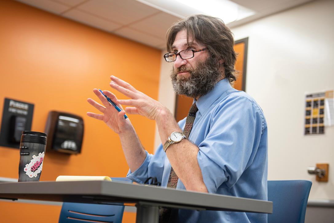 Schuster speaks to students during a history class.