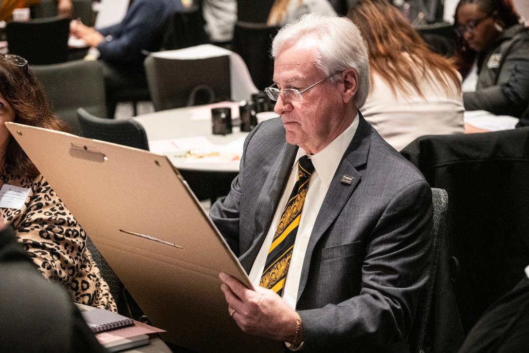 Chancellor writes on a large notepad at the Strategic Plan event.