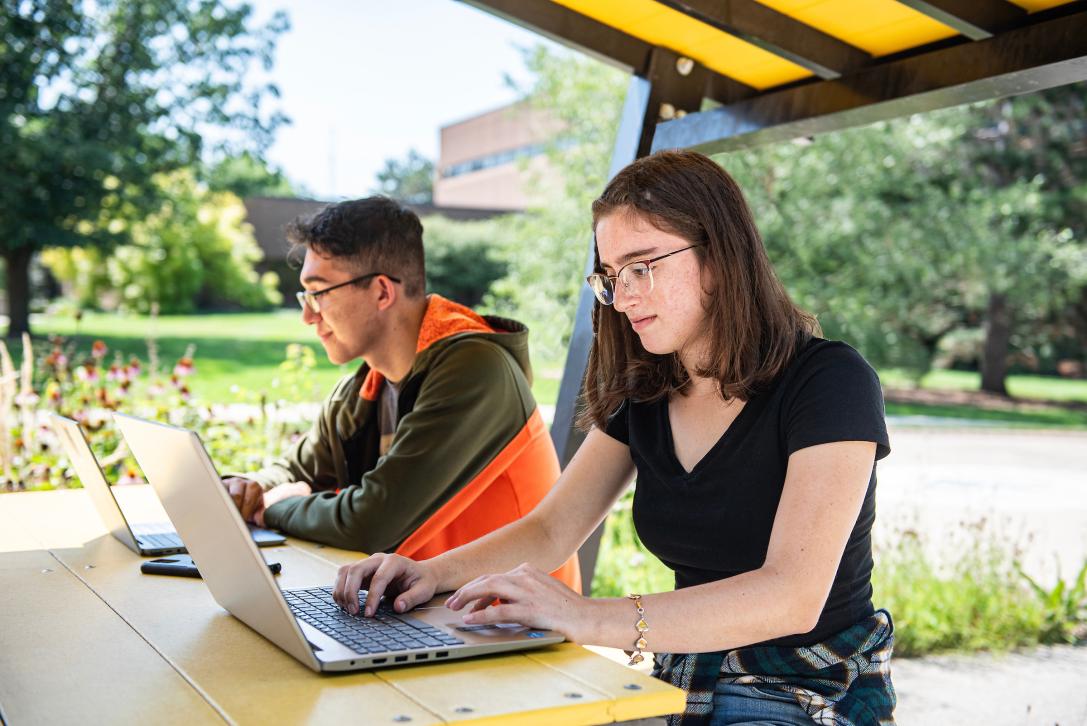 Students working on assignments outside.