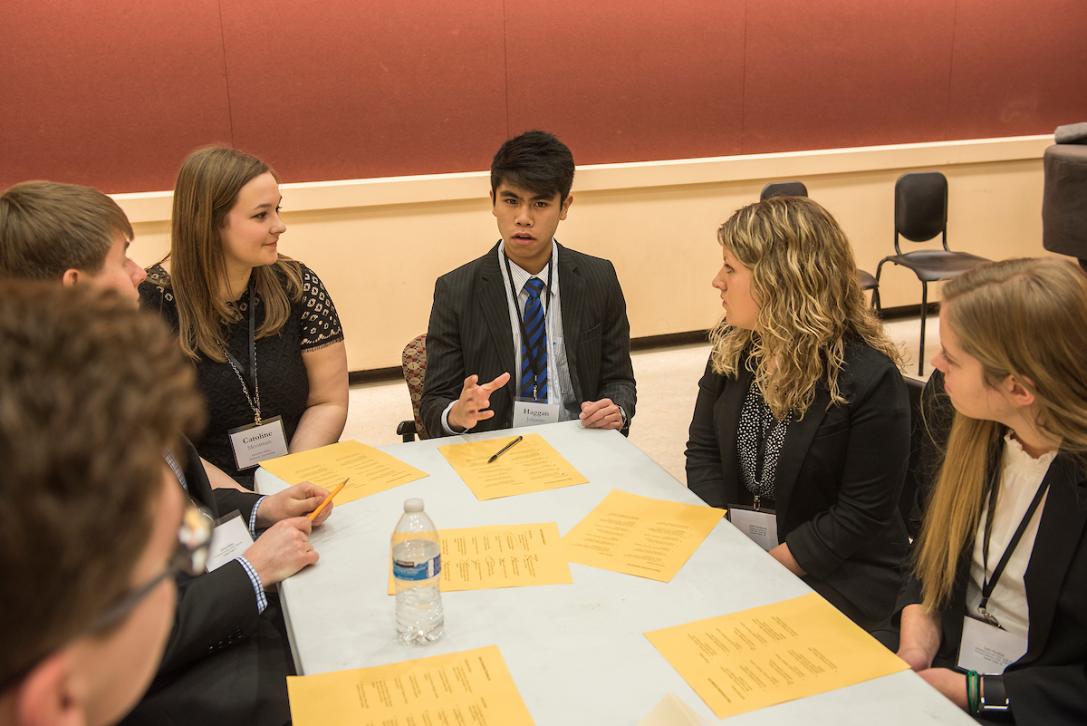 Summit scholars chat at a table.