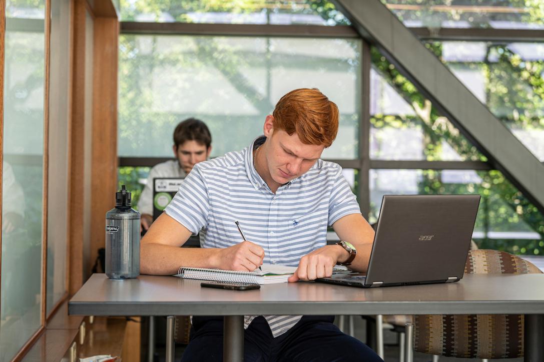 Student on the sky bridge studying and writing.