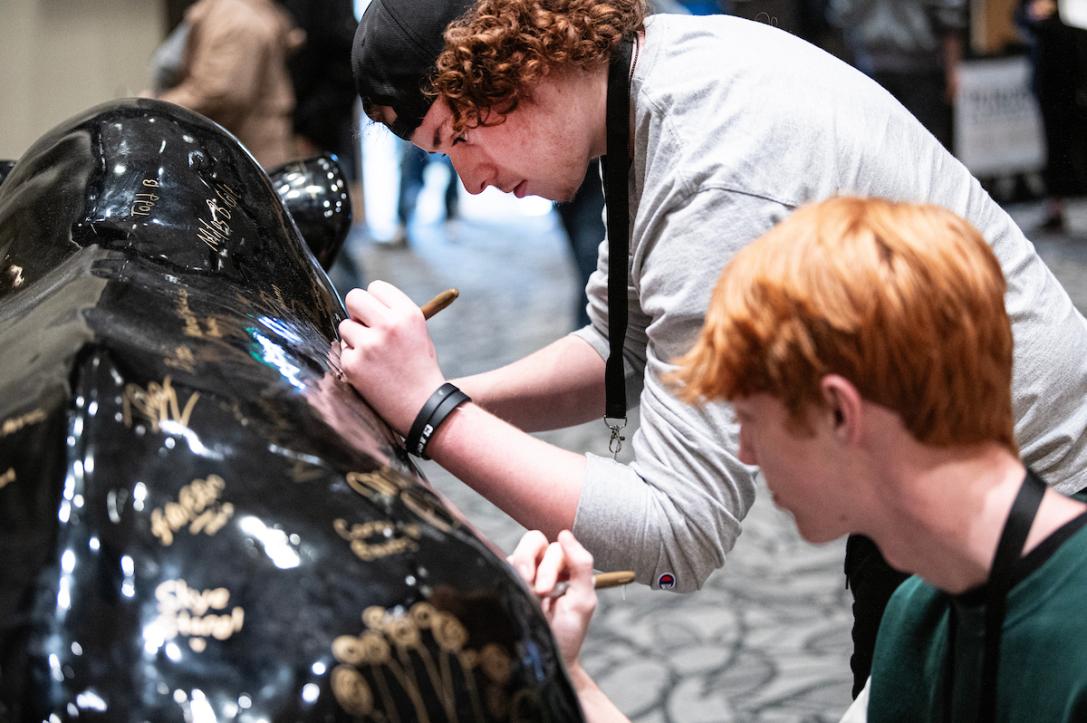 New students sign the Mastodon on Admitted Student Day.