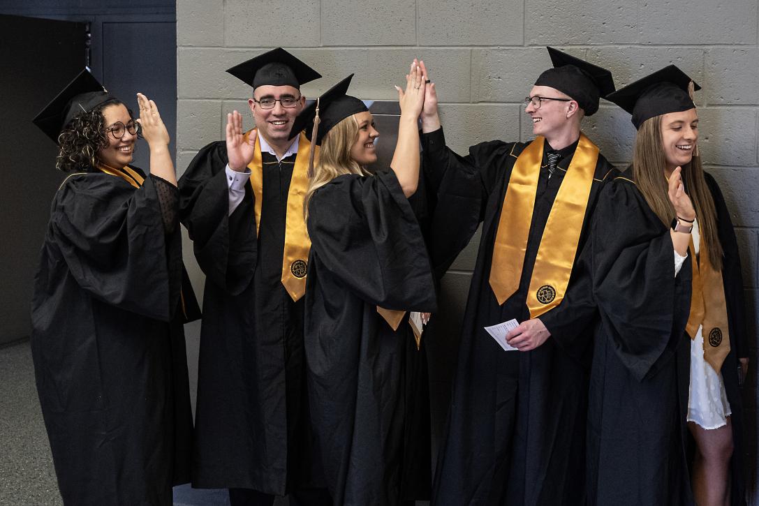 Graduating students high five.