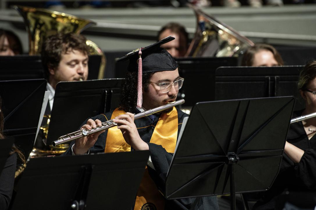 Band plays instruments to initiate the opening sequence of commencement.