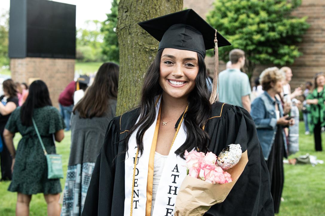 Graduate holding flowers.