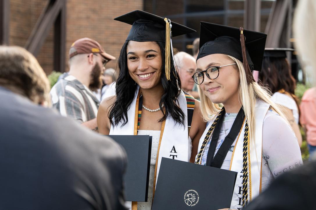 Students pose for photos with degree holder