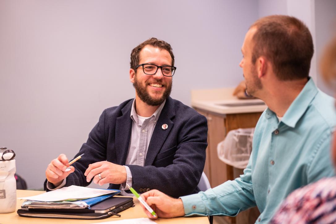 Two male students chat during a class.