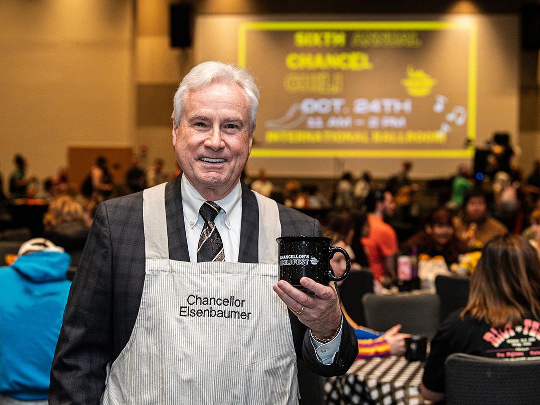Chancellor Ron Elsenbaumer is holding a bowl of chili