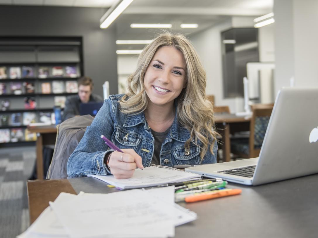 Student studying her class notes on her laptop.