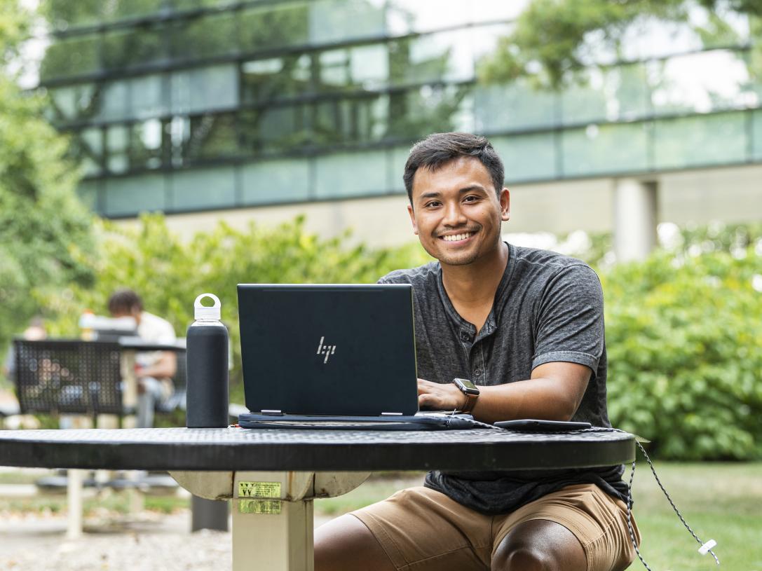 Student studying his class notes on his laptop.