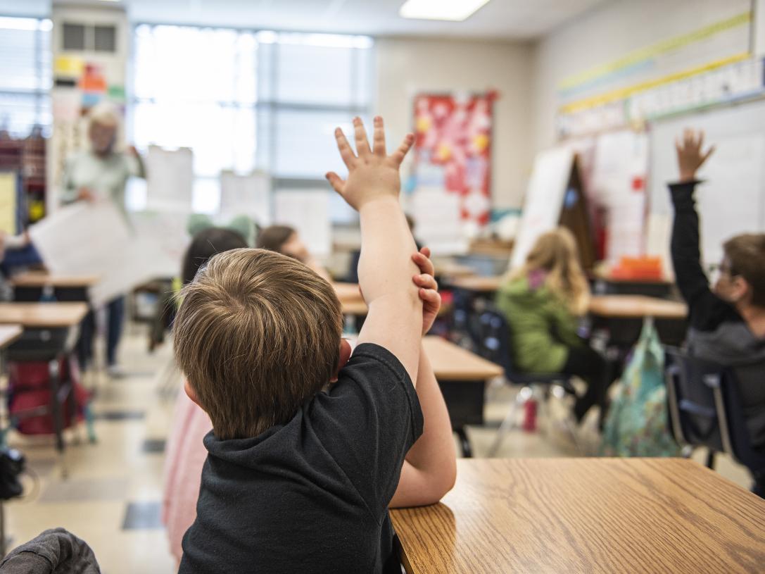 A child has a question in an elementary classroom