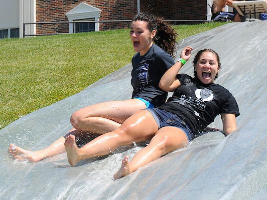 Two female students on a water slide during field day