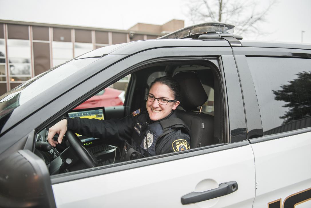 Police officer smiling in car.