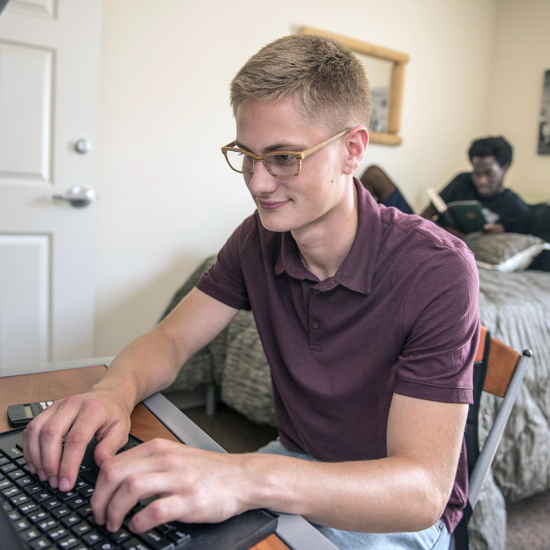 PFW students studying in their student housing bedroom.