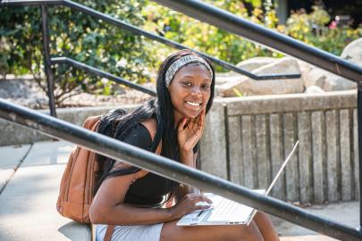 Female student sitting and studying outdoors.