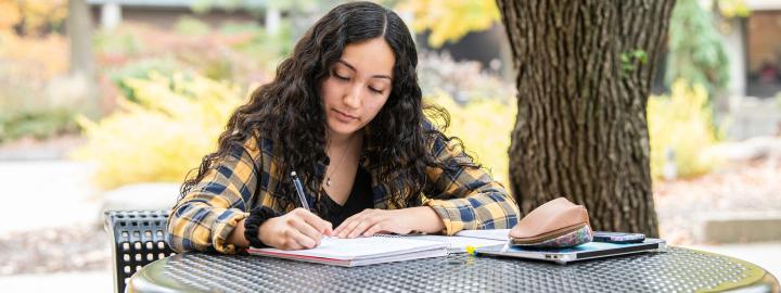 Student writing outdoors