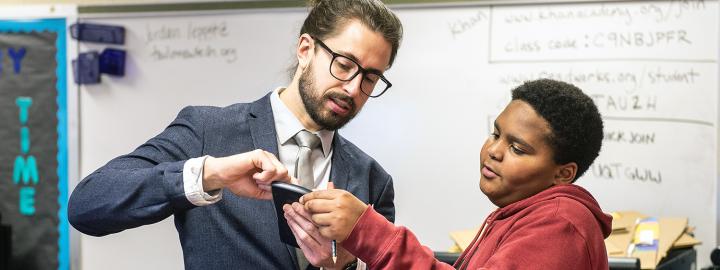 A student teacher is is instructing a student in a classroom