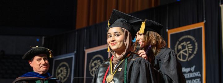 Honors student on stage at commencement.