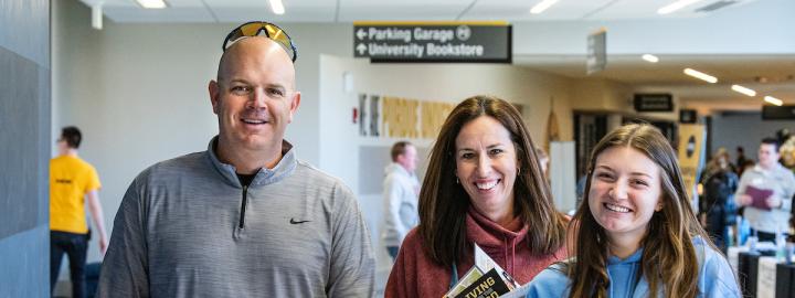 Parents fall a new student during campus visit day.