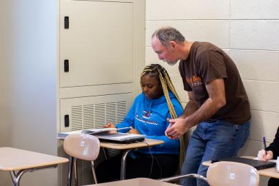 Alumni working with student in high school setting.