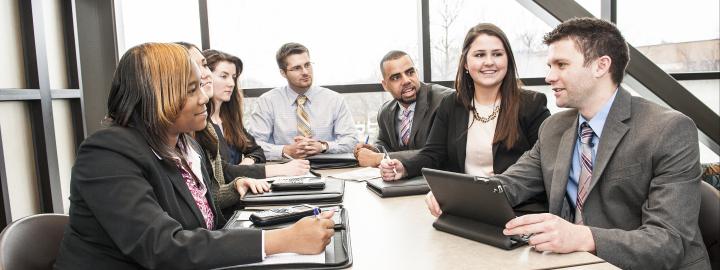 A diverse group at a table in business attire