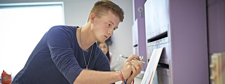 A VPA student practices airbrushing in a design lab