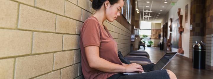 Student studying her class notes on her laptop.