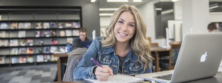 Student studying her class notes on her laptop.