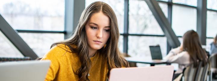 Student studying her class notes on her laptop.