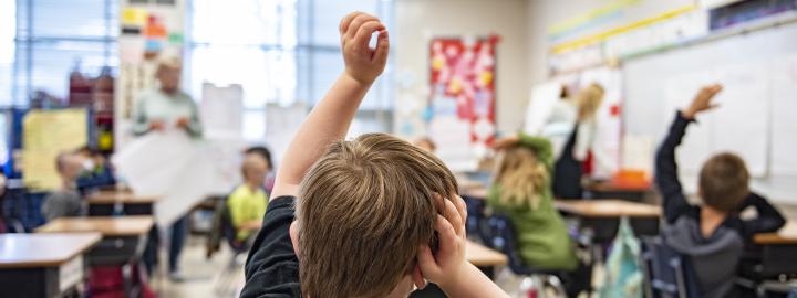 A child has a question in an elementary classroom