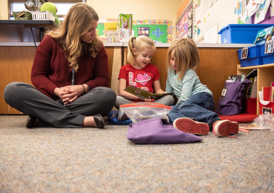 Teacher and young students reading