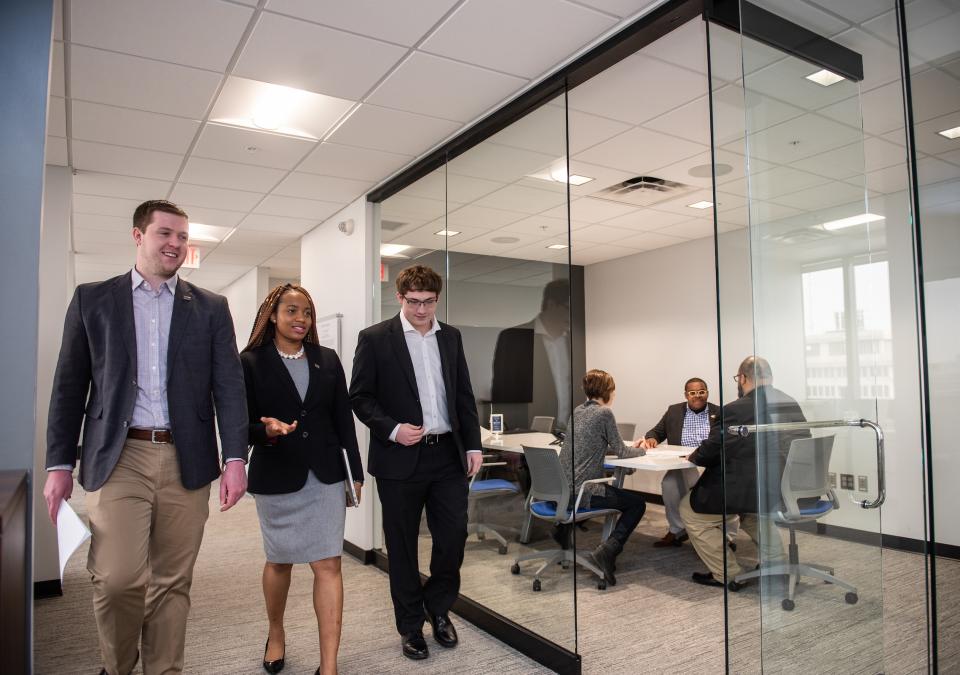 Business students walk down a hallway.