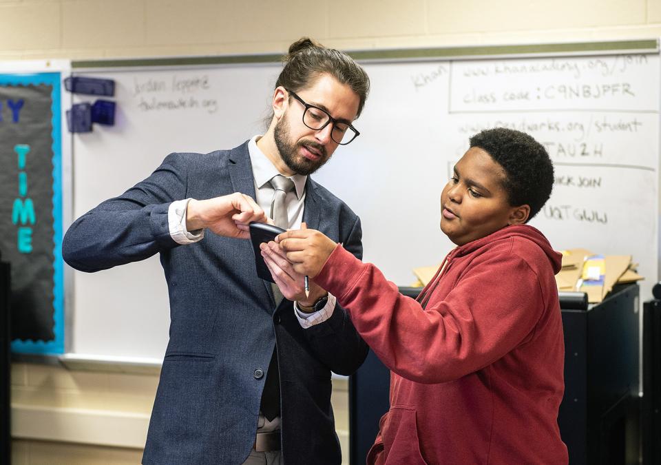 A student teacher is is instructing a student in a classroom