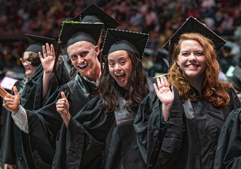 Several graduates are waving