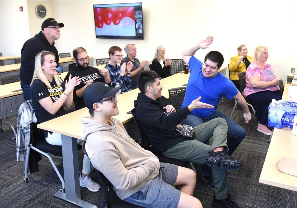 A gathering of students, faculty, and staff from the Doermer School of Business respond to positive news during the results webcast for the 2022 Flipping Finance Challenge