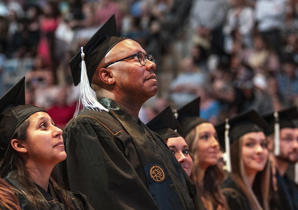 Students standing in the Coliseum at the 2022 Commencement.