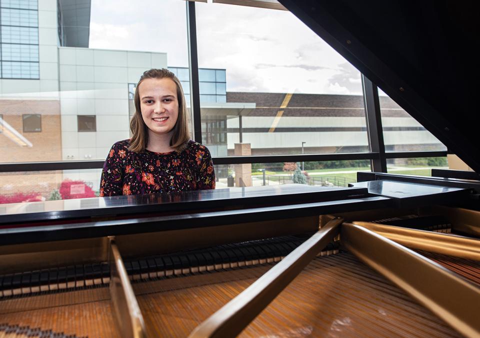 Cecilia Horner is smiling behind a grand piano