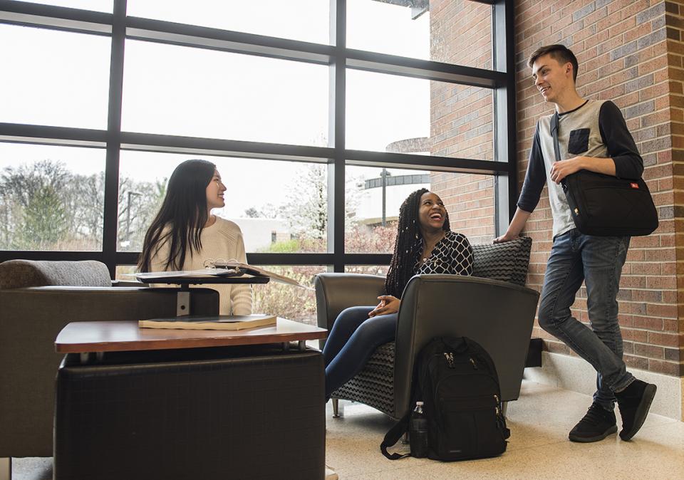 Three students are chatting in a hallway in Walb Student Union.