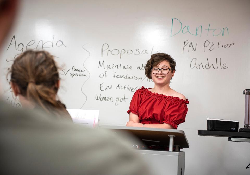 A student gives a presentation at the front of a history class.