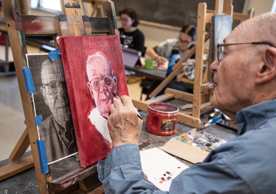 Alan Grinsfelder is painting his self portrait.