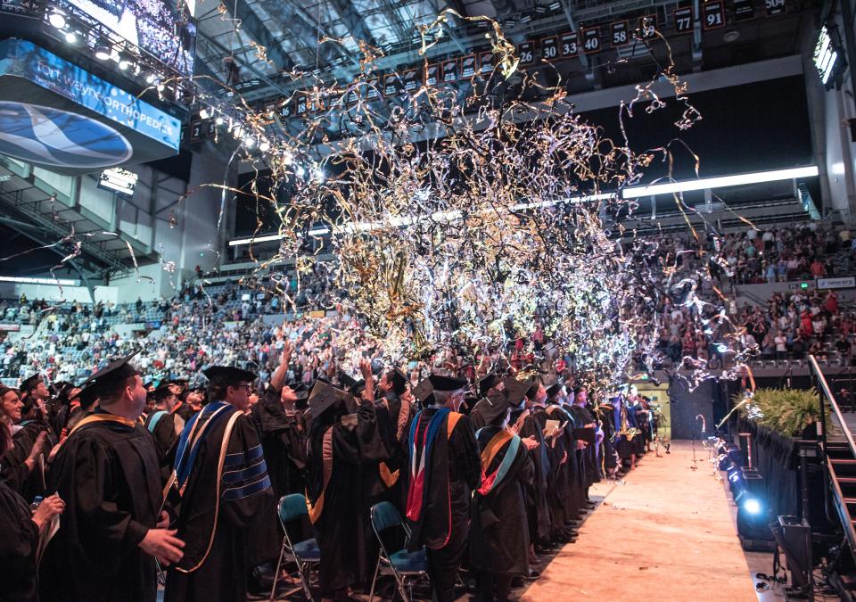 Streamers and confetti over the graduation crowd.