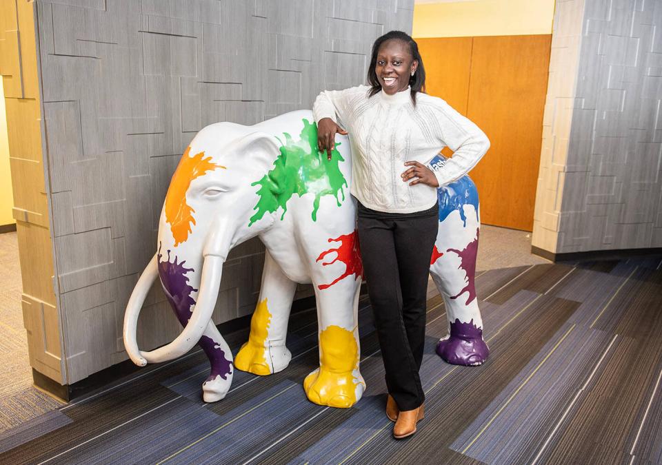 Kaliyat Gamba is standing beside a mastodon statue.